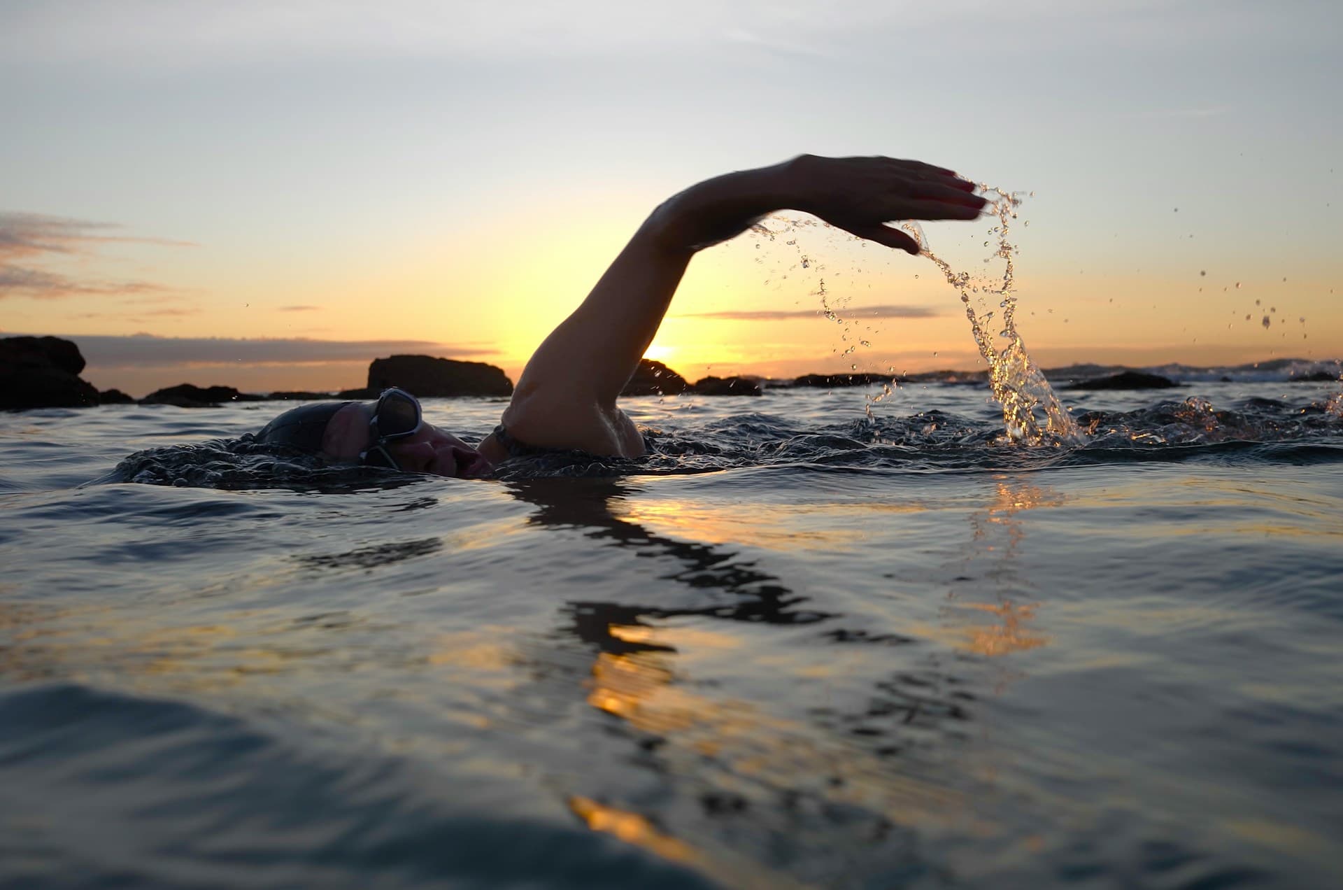 A lone swimmer far out in the open ocean, seen from a distance